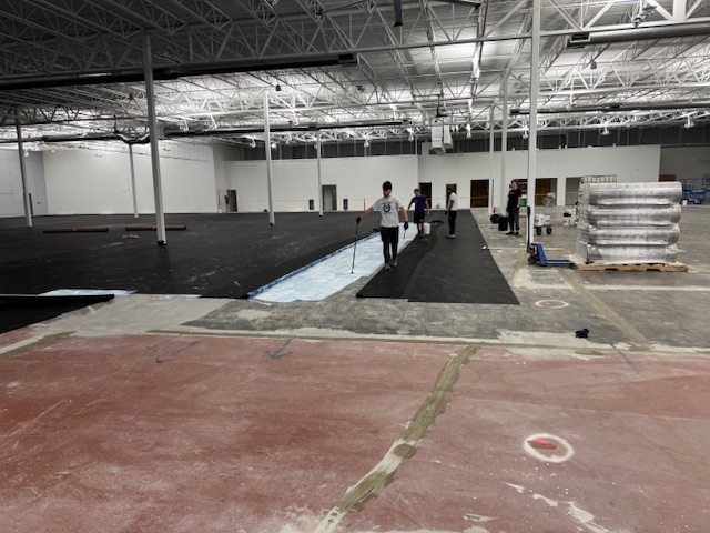 Glue being applied to hold down rubber mat