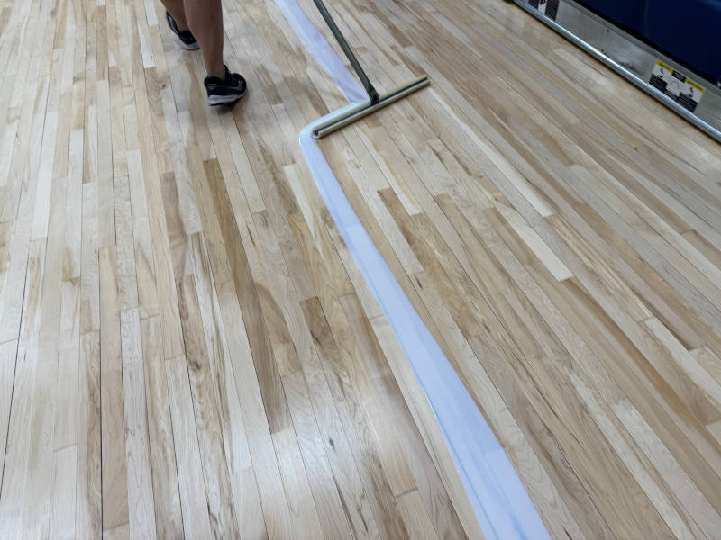 worker coating hardwood floot