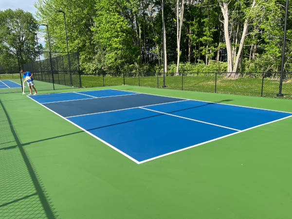 Finishing touches on a pickleball court with new surface